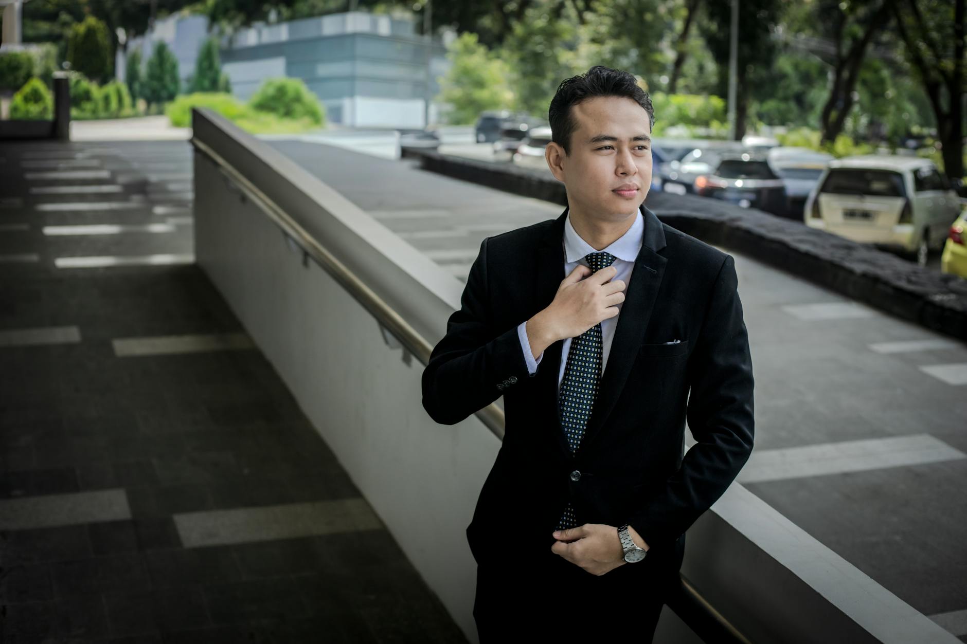 man adjusting a silk tie in a formal setting