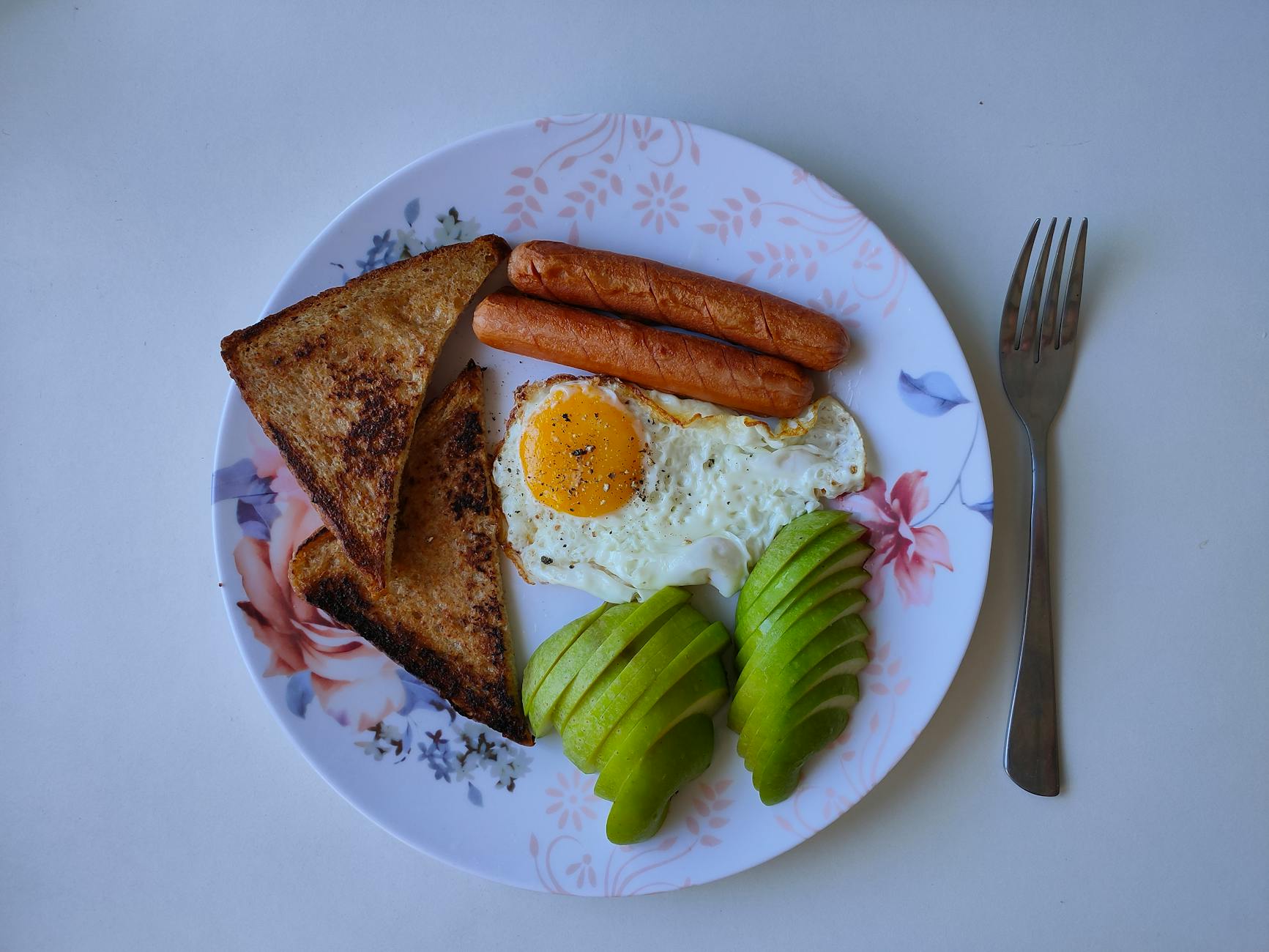 a balanced breakfast plate featuring eggs, avocado toast, and fruit