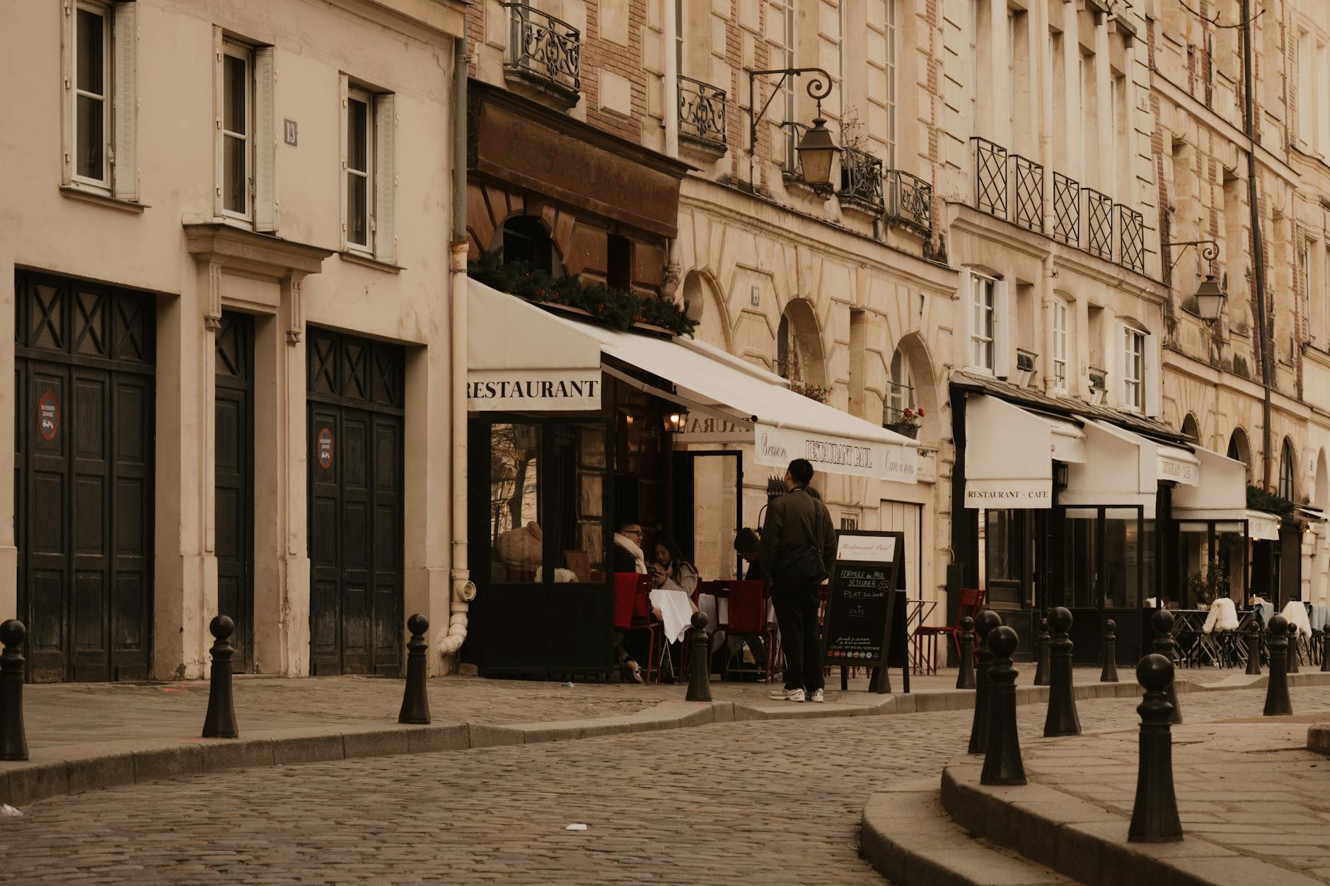 Charming Paris street with cafes and people walking
