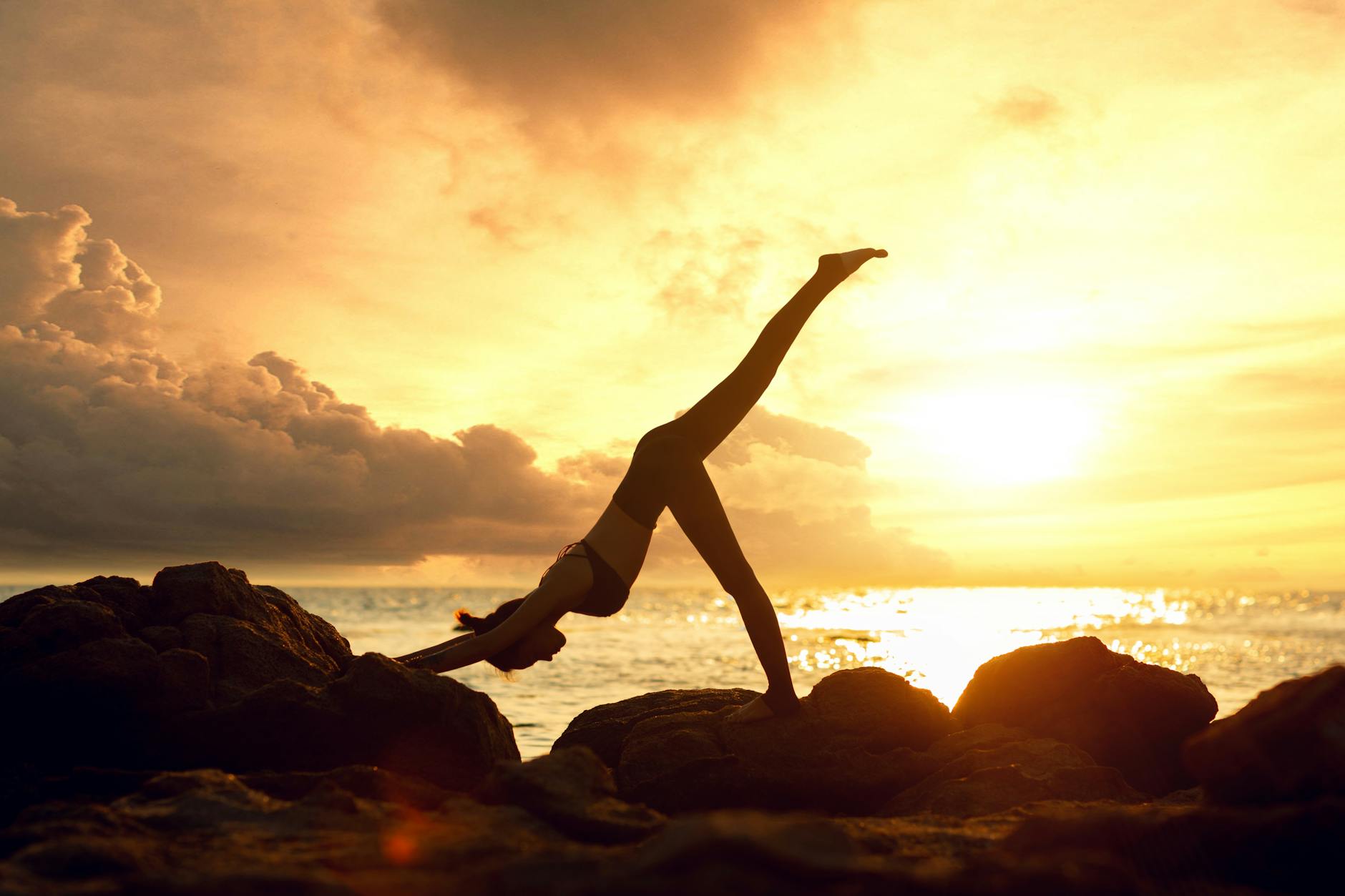 person practicing yoga outdoors at sunset
